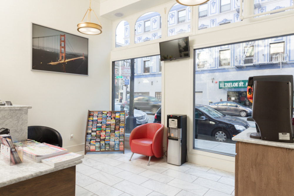 A hotel lobby with a reception desk, seating area, and city view